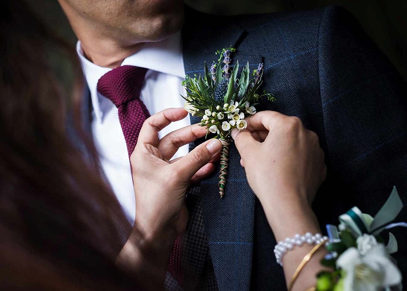 Groom having his button-hole pinned to his jacket